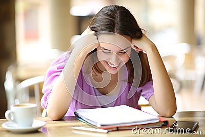 Happy student studying memorizing in a terrace Stock Photo