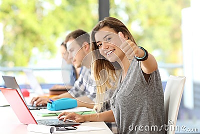 Happy student with thumbs up in a classroom Stock Photo