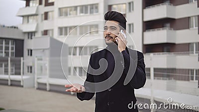 Happy stylish businessman hear good news on the phone and rejoices with happy emotions outdoors near office building Stock Photo