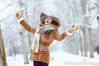 Happy stylish female rejoicing outdoors in city park in winter Stock Photo