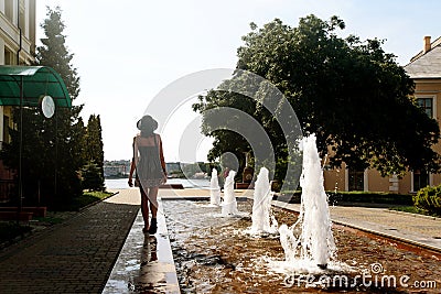 Happy stylish woman hipster walking in city street near fountain Editorial Stock Photo