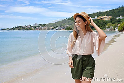 Happy stylish young woman walking on Jurere beach, Florianopolis, Santa Catarina Island, Brazil Stock Photo