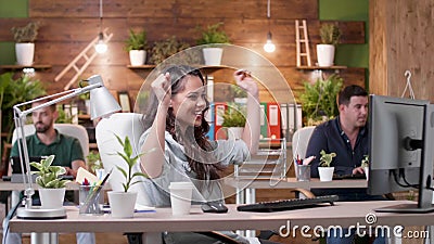 Happy succesful excited businesswoman sitting at desk table having raised hands Stock Photo