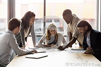 Happy successful mixed race business team discussing project ideas. Stock Photo