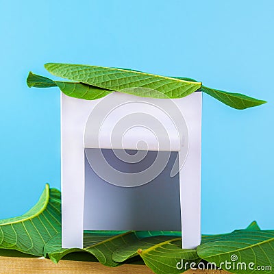 Happy Sukkot. A hut made of paper covered with leaves on a blue background. Copy the space. Stock Photo