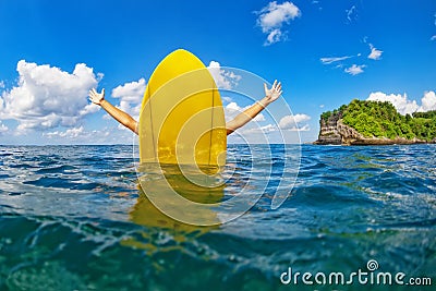 Happy surfer girl sit on yellow surfboard in ocean Stock Photo