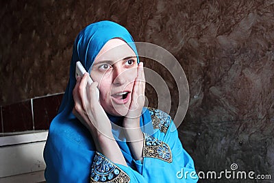 Happy surprised arab muslim woman with mobile Stock Photo