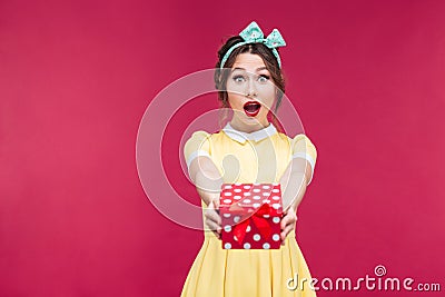 Happy surprised young woman giving you a gift box Stock Photo