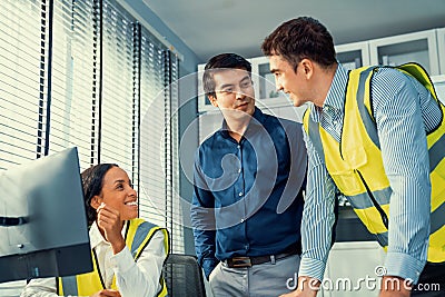 Happy team of competent engineers and investor smile and work together. Stock Photo