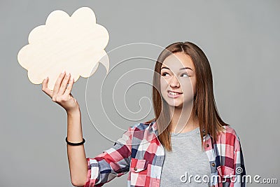 Happy teen girl holding thinking bubble and gesturing V sign Stock Photo