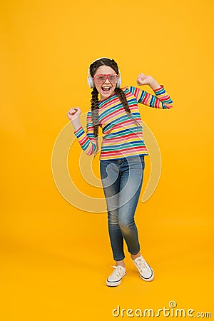 Happy teen girl wear modern headphones. funny kid listen music. beauty in glamour glasses. childhood happiness. smiling Stock Photo