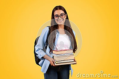 Happy teen student lady with backpack in glasses hold many books, enjoy study Stock Photo