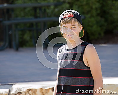 A Happy Teenage Boy in a Cap Smiles for a Portrait Stock Photo