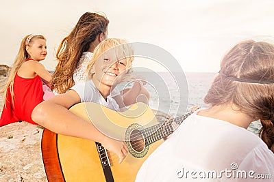 Happy teenage boy playing guitar on the beach Stock Photo