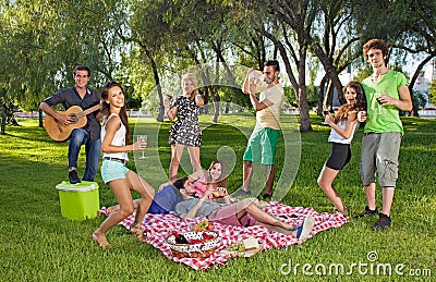 Happy teenage friends enjoying a picnic outdoors Stock Photo