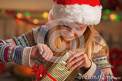 Happy teenage girl in santa hat opening christmas present box Stock Photo