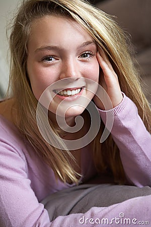 Happy Teenage Girl Sitting In Bedroom Stock Photo