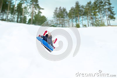 Happy teenage girl sliding down on snow tube Stock Photo