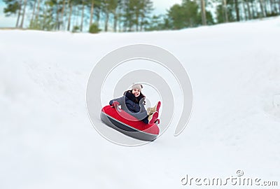 Happy teenage girl sliding down on snow tube Stock Photo