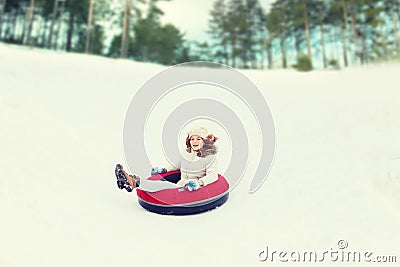 Happy teenage girl sliding down on snow tube Stock Photo