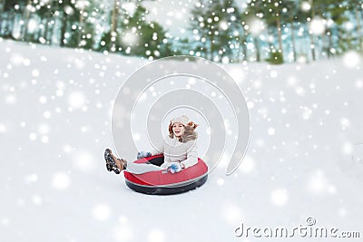 Happy teenage girl sliding down on snow tube Stock Photo