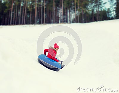 Happy teenage girl sliding down on snow tube Stock Photo