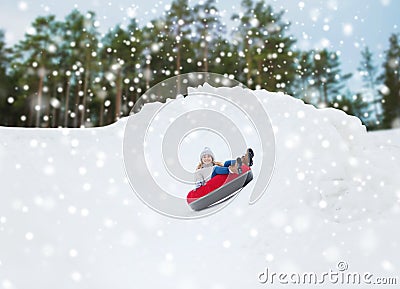 Happy teenage girl sliding down on snow tube Stock Photo