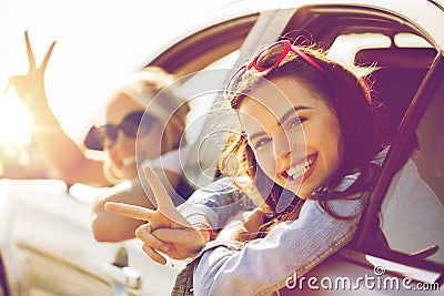 Happy teenage girls or women in car at seaside Stock Photo
