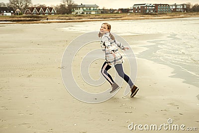 Happy teenager child girl walking and playing on Baltic sea beach Stock Photo