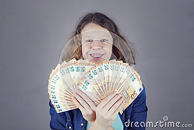 Happy teens girl holds in her hand euro Stock Photo