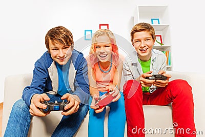 Happy teens hold joysticks and play game console Stock Photo