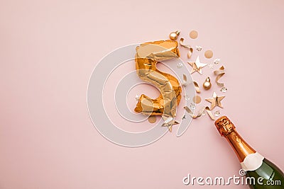 Happy 5th anniversary party. Champagne bottle with gold number balloon. Stock Photo