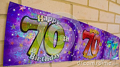 Happy 70th Birthday banner on wall Stock Photo