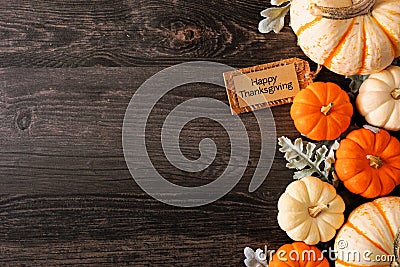 Happy Thanksgiving tag with fall side border of pumpkins and leaves on a dark wood background Stock Photo