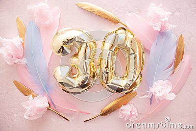 Happy birthday with golden number thirty 30 air balloons and blue feathers with colorful decorations on pink Stock Photo