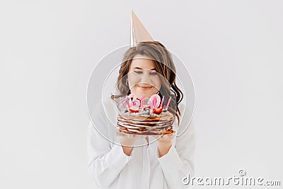 a happy thirty-year-old woman with a birthday cake with candles. Stock Photo