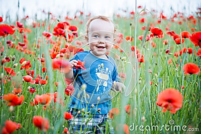 happy toddler smiling in a field of poppies Stock Photo