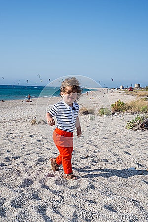 Happy toddler walking with hair in the wind Stock Photo