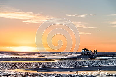 Happy tourists enjoy Sunset during four wheel tour in Salt flat Lake Salar de Uyuni in Bolivia Editorial Stock Photo