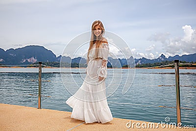 Happy Travel Girl Fun on Wooden Pier with Lake, Rainforest Jungle and Mountains Stock Photo