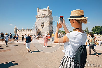 Happy traveler girl in Lisbon near Belem Tower. Tourist woman taking picture of Belem Tower, Portugal Stock Photo