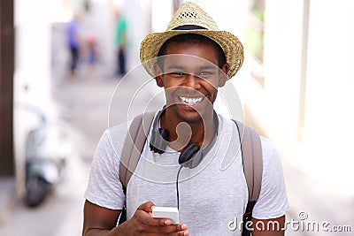 Happy traveler walking in town with mobile phone Stock Photo