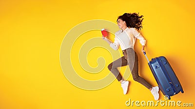 Happy Traveler Young Lady Running With Suticase On Yellow Background Stock Photo
