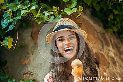 Happy trendy tourist woman in Pienza, Italy eating ice cream Stock Photo