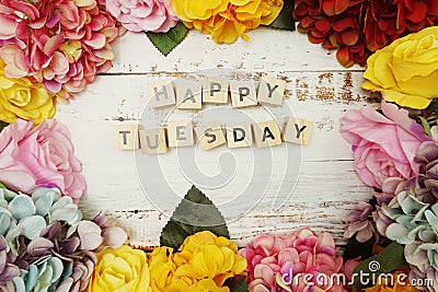 Happy Tuesday alphabet letter with colorful flowers border frame on wooden background Stock Photo