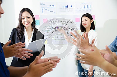 Happy two business women making a successful business presentation. Meet the goal resolution of the year. Team colleague clap for Stock Photo