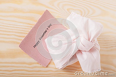 Happy valentine's day on card with eco-friendly pink gift. on a wooden background Stock Photo