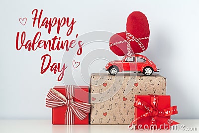 Happy Valentine`s Day card. Red retro toy car with plush heart Stock Photo