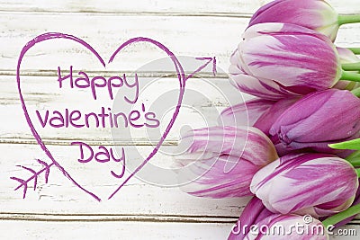 Happy Valentine`s Day greeting with tulips on weathered wood Stock Photo