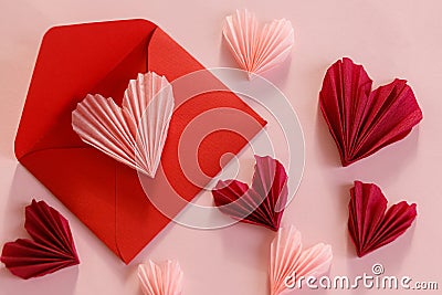 Happy Valentine`s day! Stylish pink hearts and red envelope flat lay on pink paper background. Modern Valentines day composition. Stock Photo